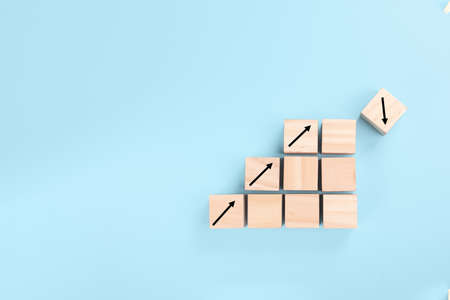 the concept of risk in business. growth on stacked wooden cubes on blue background. Financial or...