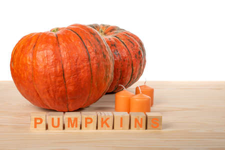 two pumpkins and candles on a wooden table, preparing for Halloween concept. white background. copyspaceの写真素材