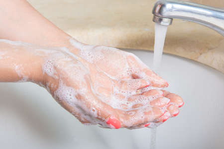 Woman Washing hands to prevent spread of CoronaVirus as well as cold, flu, bacteria at home. Hygiene...
