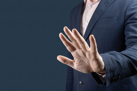 businessman with stop gesture. Businessman in suit making stop gesture, holding his palm outward over blue background. man hand stop signの写真素材