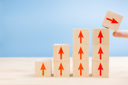 Wood block cubic stacking step up with RED Arrow Blue background. Business growth success process....