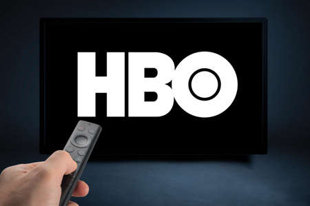 USA, NEW YORK February 2, 2021: Close up of Nvidia Sheild TV Remote in Hand and TV Screen with HBO Logo, HBO is a well known global provider of streaming movies and TV seriesのeditorial素材