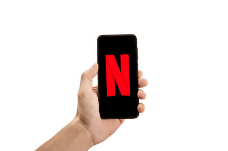 USA, NEW YORK February 2, 2021: Close up of phone with NETFLIX new logo in man Hand. Netflix is a well known global provider of streaming moviesのeditorial素材