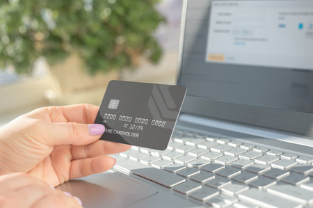 Hand holding credit card and using laptop. Online shopping, e-commerce, internet banking, spending...