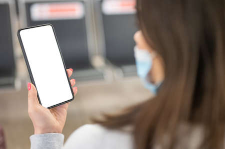 Hands traveler using smartphone mobile in the airport lounge. woman holding cell phone in hand in...