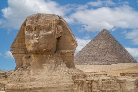 The front face and body of the Sphinx and the biggest Great Pyramid of Khafre appear side by side in the desert of Giza, Cairo, Egypt. Horizontal Copy Space. The Sphinx in Giza pyramid. blue skyの写真素材