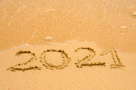 2021 number lettering on the sea beach, wave and golden light of sunset. number 2021 on perfect tropical sandy beach. Travel vacation concept. copy spaceの写真素材