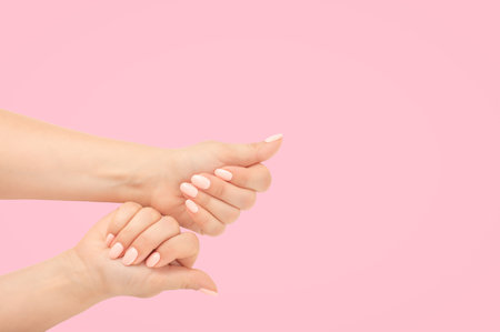 Close-up women's hands with beautiful manicure isolate on pink background. top view. Stylish trendy nail young woman hands pink manicure on pink background. copy spaceの写真素材