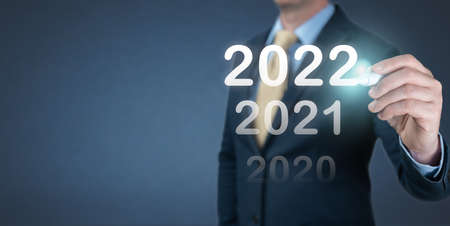 hand businessman writing 2022 number on virtual screen. Business and Technology target set goals and achievement in 2022 new year resolution, planning and start up strategies and ideasの写真素材