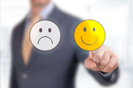 Close up customer hand choose smiley face icon. Businessman hand pointing the optimist icon from...