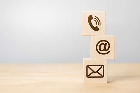 Contact us concept, Wood block symbol telephone, mail, and address on desk. Close-up Of Various Contact Options on wooden cubes. Wood block symbol telephone, mail, and address on desk. copy spaceの写真素材