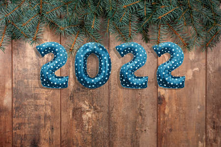 Happy New Year 2022. Foil balloons numbers 2022 on wooden rustic table with branches of Christmas trees. Happy New Year 2022 celebration. Flat lay, top viewの写真素材