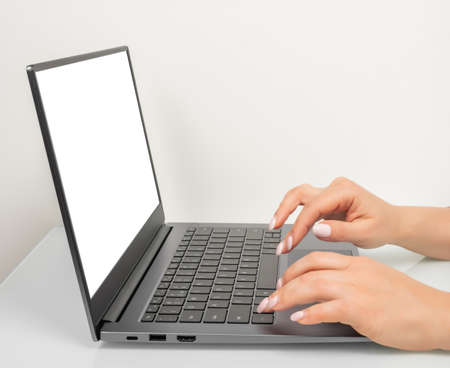 Business woman hands using mockup laptop with white blank screen. side view. hand woman work using laptop with white background for advertising,contact business search informationの写真素材