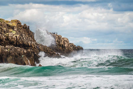 Rock Formations On Beach Against Sky. beach with large rocks on shore and in water. Powerful waves...