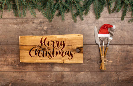 Festive New Year Christmas dinner concept. Christmas decorations and Cutlery on wooden rustic table. Christmas table place setting. Winter holidays background. Top view, flat lay, copy spaceの写真素材