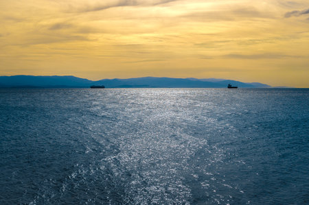 seascape with dark blue sea and yellow sunset sky. Colorful sunset and cloudy sky over dark islands against dark blue sea. Panoramic view of the coast of Turkey near Izmit Bayの写真素材