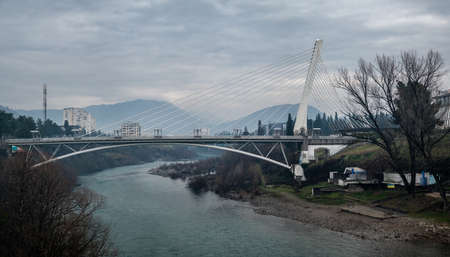 Millenium bridge over the river Moraca in Podgorica, Montenegro. View of Podgorica city with the...