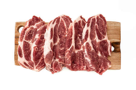 Top view of raw pork steaks in row on wooden board. isolated on white background. Raw meat on wooden cutting board. fresh raw beef lamb. cooking pork meat on white. Butchery, market, shopの写真素材