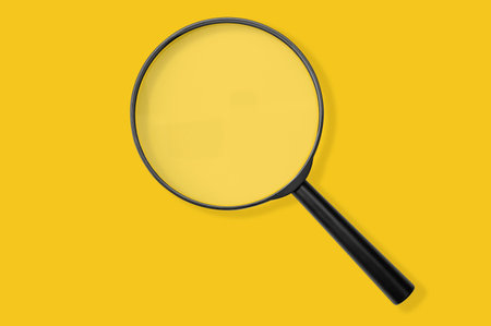 Magnifying glass black color isolated on yellow. Research, searching sale or investigating something. top view. Black Magnifying glass with soft shadow on yellowの写真素材