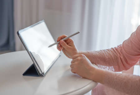 female artist using smart stylus for drawing picture on tablet touch screen device, working home....