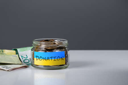 donation for ukrainian refugees. Donation for Ukraine concept. Help and financial assistance to Ukraine. donation jar with Ukrainian flag. Ukrainian war, donations,の写真素材