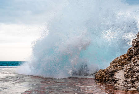 Big wave splash on pier. sea wave breaking on pier. Waves crashing on breakwaters. Waves and a storm at seaの写真素材