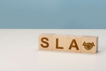 SLA Service Level Agreement acronym, business concept. Service performance tracking to reduce uncertainty the customer in process. Hand flips wood cube with SLA. Economic, financial, management, business conceptの写真素材