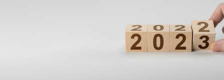 happy new year concept, Flipping of wooden cube block change from 2022 to 2023. Wooden cube with...