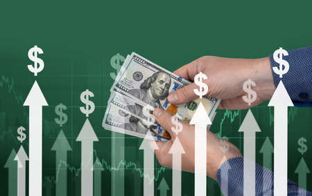 inflation. hands with banknotes of American dollars against background of arrows and dollar signs....