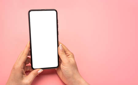 Woman hand using cellphone isolated on pink background. female hands with cell phone. mobile phone...