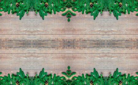 Christmas frame with fir tree branches on wooden background. Top view xmas backdrop with space for greetings. christmas decoration over old wooden backgroundの写真素材