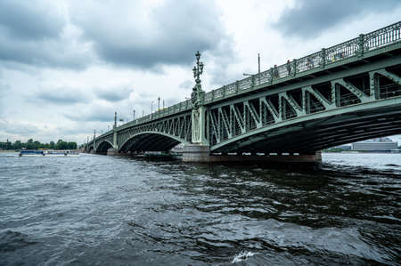Bridge. A low metal bridge across the river in cloudy weather in gloomy dark colors. St. Petersburg. bridgeの写真素材