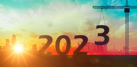 2023 Happy new year Silhouette of construction to create lifting crane 2023 on sunset background....