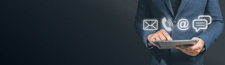 Contact us or Customer support hotline people connect. . Close up businessman holding tablet, using device to contact people or contacting information on business, contact us messaging calling emailの写真素材