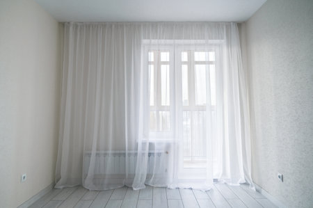 White empty modern room interior with window and balcony. Window in small, economic room background. empty room with windowの写真素材