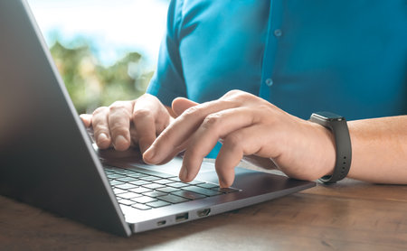 Close up of person hand typing on laptop keyboard, author writing on notebook computer, businessman...