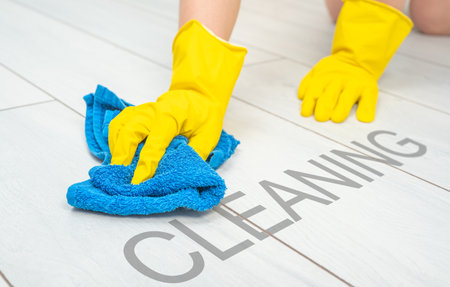 Deep cleaning service. Professional cleaner washing white floor in living room of apartment. female...