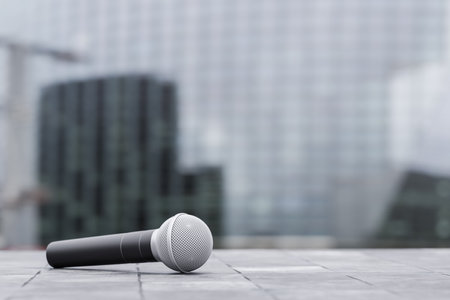 journalist microphone on city background. presentation or announcement of a report, investigative journalism or news. interview in cityの写真素材