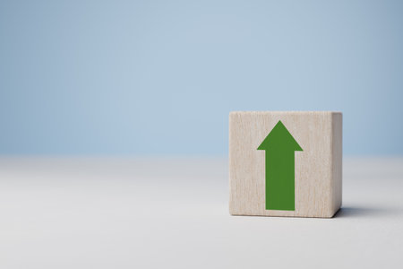 Green increasing up arrow on wooden cube block, It is a symbol of business investment growth...