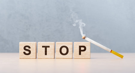 wooden cubes with inscription stop and smoking cigarette. stop smoking, tobacco ban, complete ban on tobacco cigarettes. Quitting from addiction conceptの写真素材