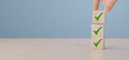 checklist and green check mark icons on wooden cubes on table background. Business task sign...