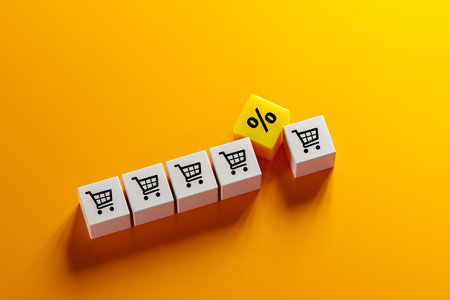 sales growth. shopping cart icon and percentage sign on cubes laid out on orange background....