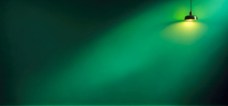 ceiling light in dark room. Green Empty wall with spotlight with copy space. Place for text or product presentation. Lighting effect green color glow on dark wall backgroundの素材