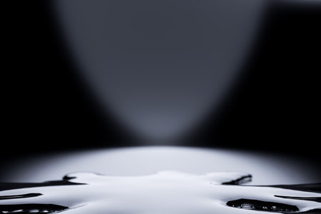 minimalist monochromatic setting showcases liquid artfully spilled on ground. Perfect for highlighting products, it exudes contemporary style and draws attentionの写真素材