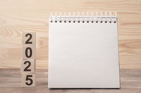 2025 time for new Year, new start. Plan words and 2025 cubes wooden table background. plans for 2025, space for your text on notepad, mockup calendarの写真素材