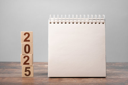 2025 mockup notepad. 2025 cubes wooden table background. New Year. plans for 2025, space for your text on notepad, mockup calendarの写真素材