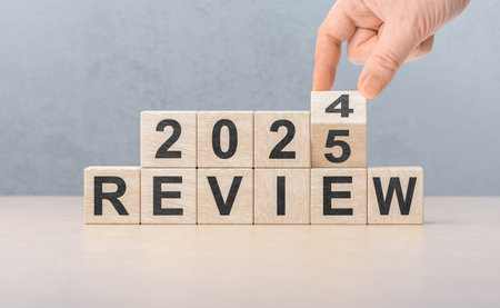 Review 2025. hand flips wooden cube and changes words REVIEW 2024 to REVIEW 2025. Business 2025...
