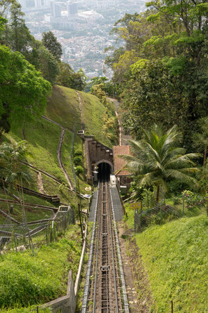Funicular railway on Penang Hill in Malaysia, traveling through lush green forest, popular tourist attraction, scenic views of nature and distant city, unique and memorable experience for visitorsの写真素材