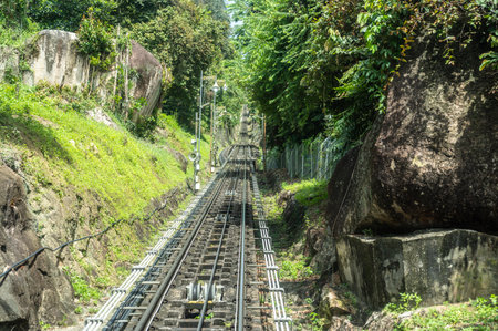 Penang Hill railway tracks leading into tunnel surrounded by lush greenery, steep incline funicular train route, scenic hillside view, popular travel destination, Malaysian heritage siteの写真素材