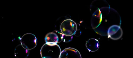 Colorful soap bubbles on black background, transparent spheres with iridescent reflections, ideal...